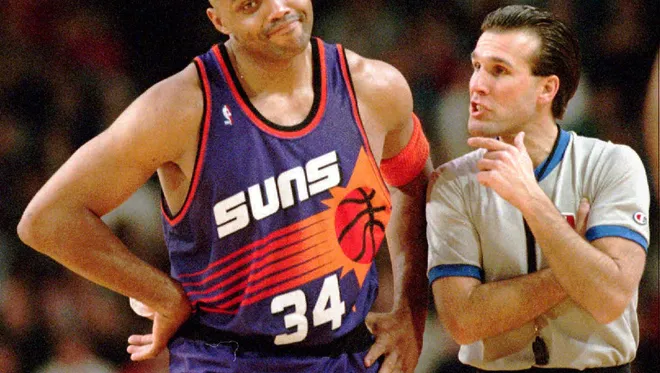 Charles Barkley in a Suns jersey with the number 34, standing next to a referee during a game. Credit: Rob Schumacher/The Republic related to Charles Barkley.