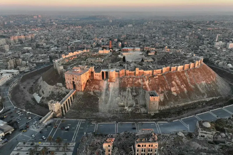 Syria in 2025: Citadel of Aleppo with cityscape at sunrise.