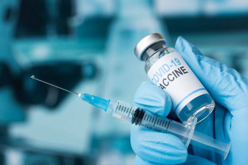 COVID vaccines: vial and syringe in hand.