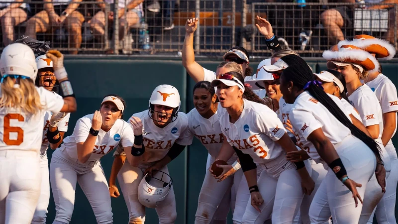 Texas softball roster: Longhorns players celebrate in white uniforms dugout.