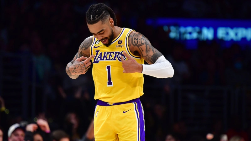 D'Angelo Russell points at his Lakers jersey, celebrating during NBA game.