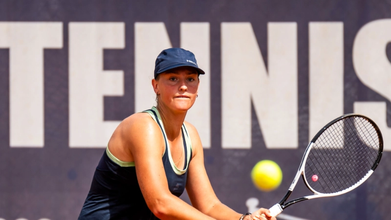 Elena Pridankina returns a tennis shot, navy dress and cap, Image Credits: (Jurij Kodrun / Stringer / Getty Images)