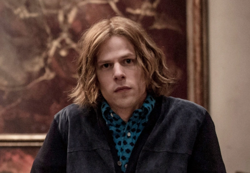 Jesse Eisenberg as Lex Luthor with long hair, blue patterned shirt, scene from Batman v Superman, Image Credits: (Clay Enos / © Warner Bros. / courtesy Everett Collection)