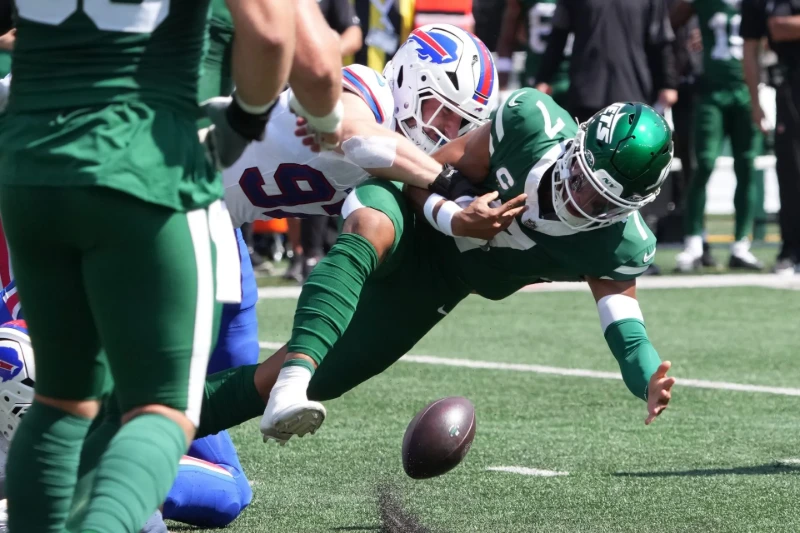 Justin Fields tackled by Bills defender, fumbles ball during Jets game.