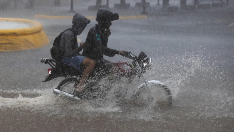 Hurricane Melissa floods city, two people on motorbike ride through deep water