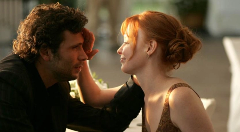 Jeremy Sisto touches co-star's face in a heartfelt dinner scene, emotional and intimate.