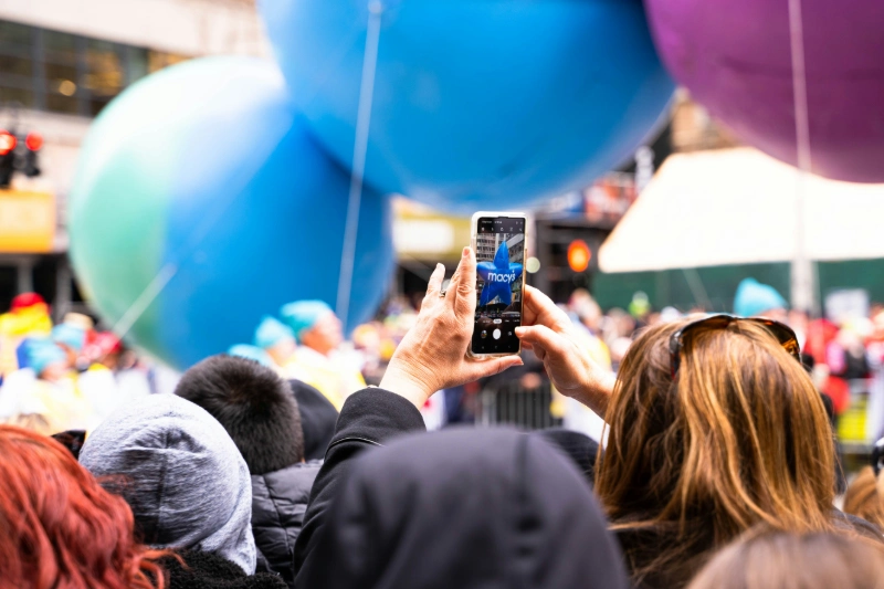 Crowd filming giant balloons at Macy's Parade on phone, image credits - Carson Masterson / UNSPLASH