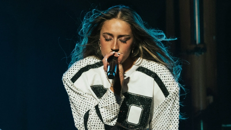 Tate McRae singing on stage. Image credits: baeth