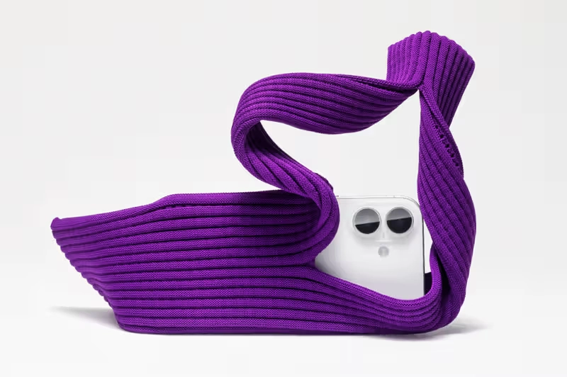 White iPhone with dual-camera stylishly wrapped in a purple ribbed Issey Miyake knit pocket case. Image Credits - Apple