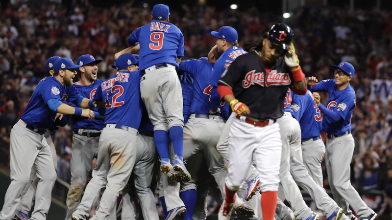 Chicago Cubs players leap and celebrate together after winning Game 7 of the World Series, while a Cleveland Indians player walks away, Image Credits: AP: Matt Slocum