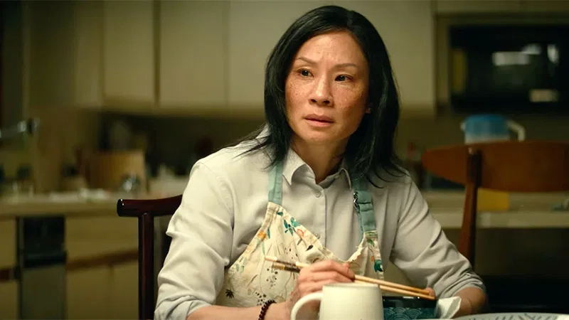 Lucy Liu in a light shirt and apron
