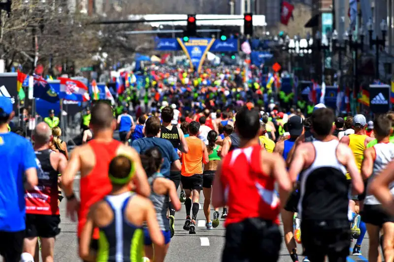 Large group of runners near Boston Marathon 2025 finish line.
