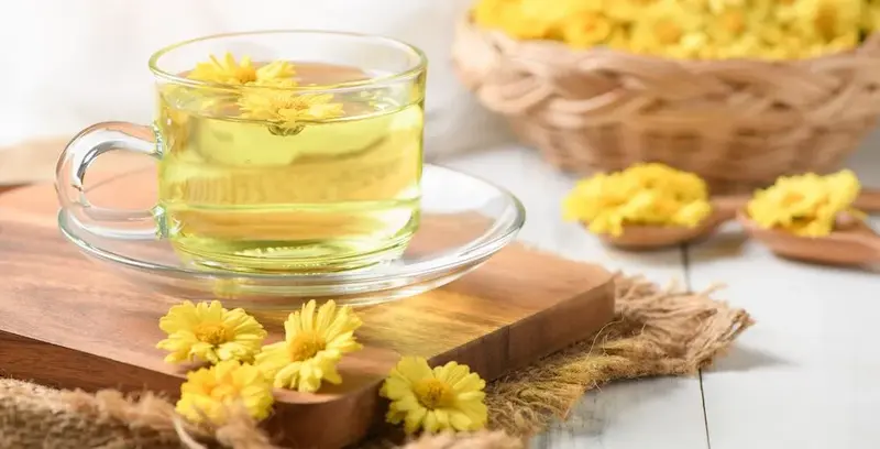 What is the tea used in Chinese restaurants: chrysanthemum tea with yellow flowers in glass cup.