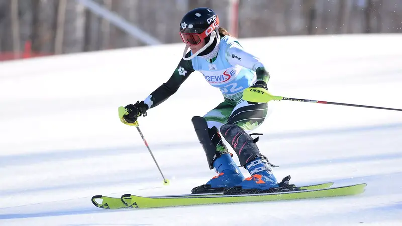 Ellery Curtis in a racing suit with the number 72, navigating a skiing course. Credit: Gil Talbot Photography related to Ellery Curtis.