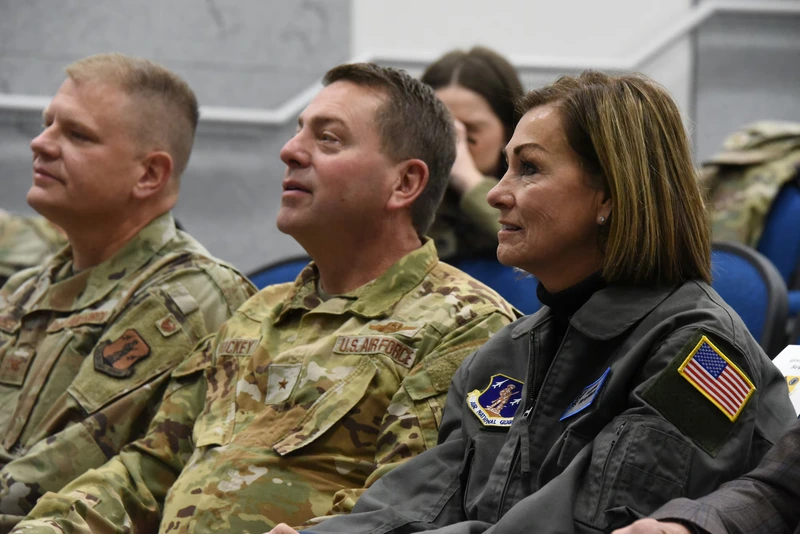 Iowa Gov. Kim Reynolds, Brig. Gen. Mark A. Muckey, and Col. Justin Wagner listen to a passenger briefing at the 185th ARW in Sioux City, Iowa.