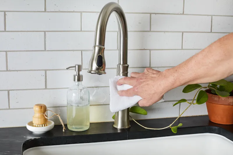 What is a deep sink: cleaning stainless steel faucet above deep kitchen sink.