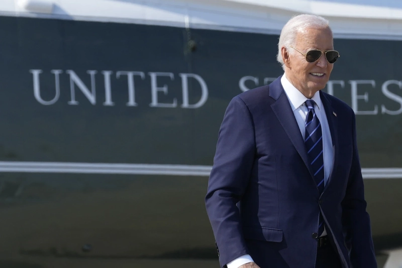 Joe Biden: walking near Air Force One with UNITED STATES in background.