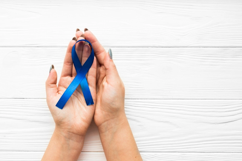 Prostate cancer awareness: hands holding blue ribbon.