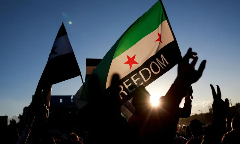 Syria in 2025: protest with opposition flag reading FREEDOM during new leadership and sanctions shift.