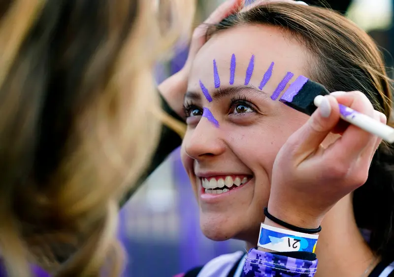 What is homecoming: student gets face painted at GCU Homecoming tailgate.