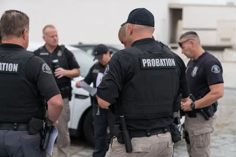 What is probation: probation officers in uniform with badges and field vests.