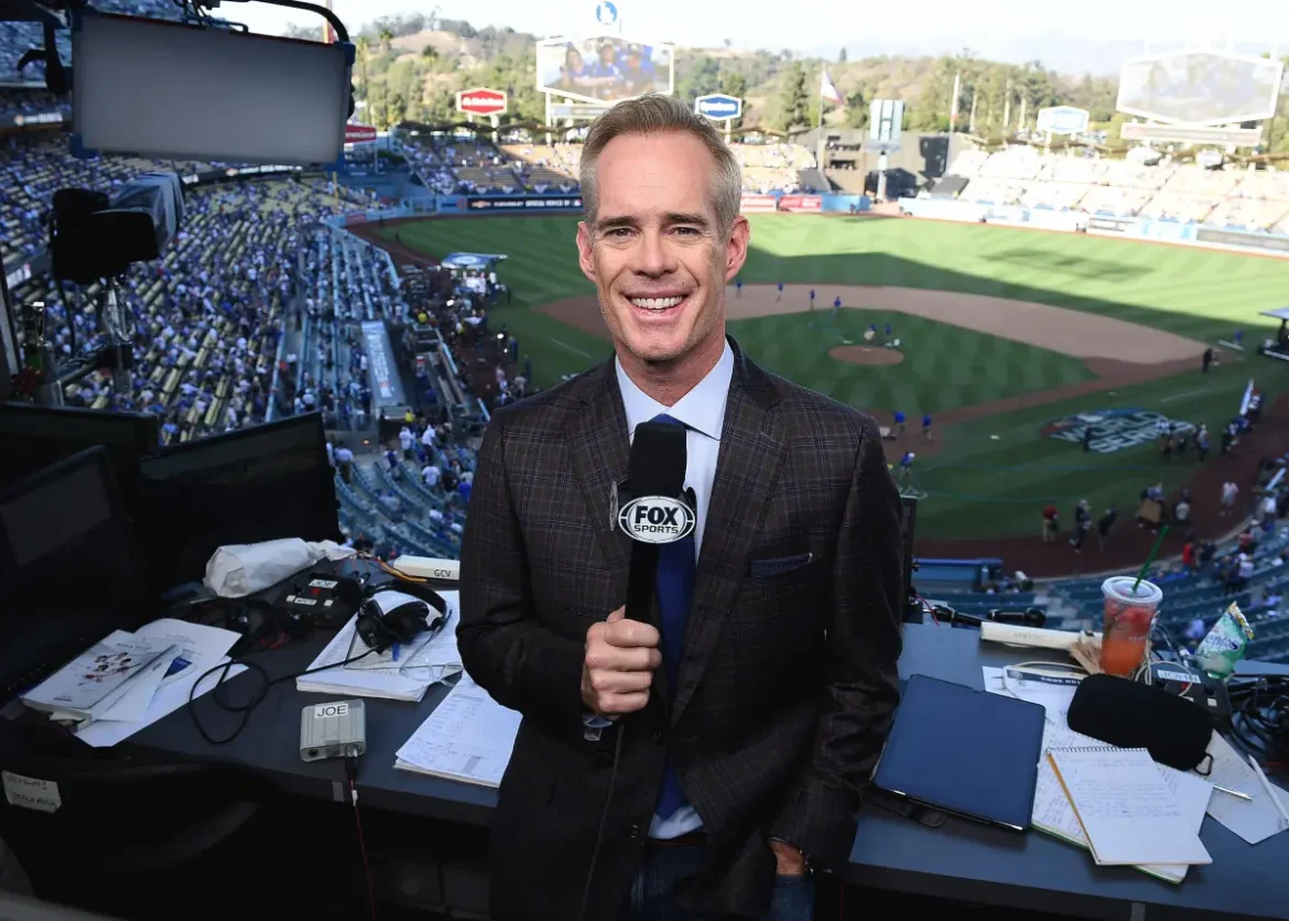 Joe Buck: broadcasting at MLB game from booth, holding FOX Sports mic.