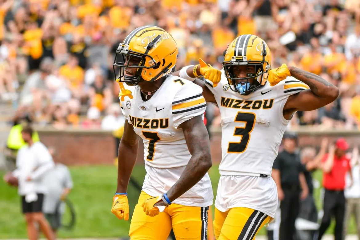 Mizzou football players flex and celebrate after a big play, game atmosphere.