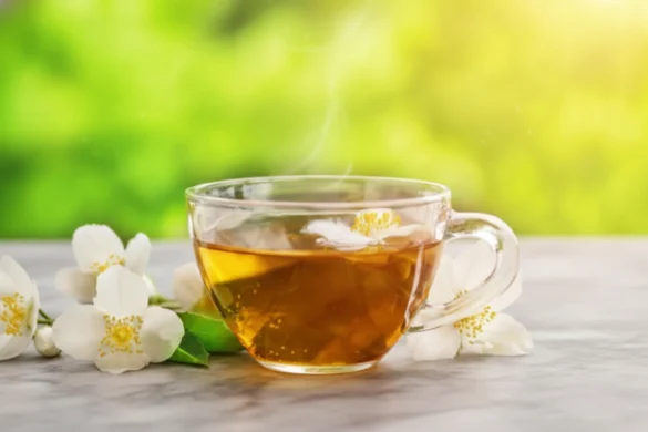 Hot jasmine tea in a glass cup with fresh jasmine flowers, outdoors in sunlight. Image Credits - Revanth Karra