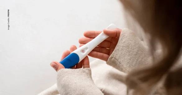 What is a Chemical Pregnancy, woman holding faint positive pregnancy test, image credits: Freepik