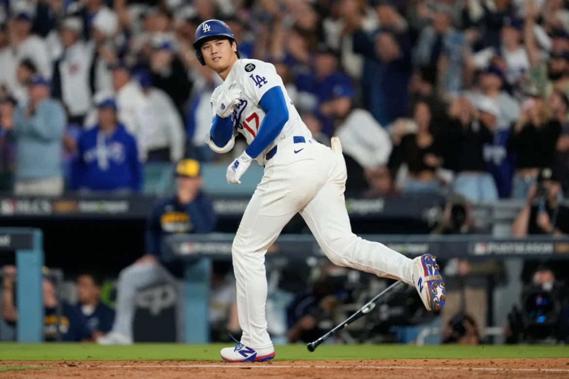 Los Angeles Dodgers player running to first base in World Series Game 7, crowd cheering, Image Credits: AP Photo/Ashley Landis