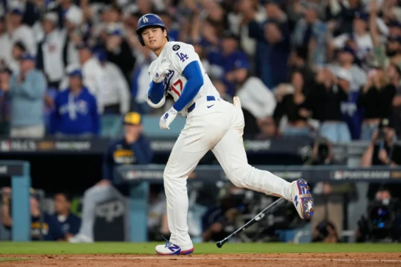 Los Angeles Dodgers player running to first base in World Series Game 7, crowd cheering, Image Credits: AP Photo/Ashley Landis