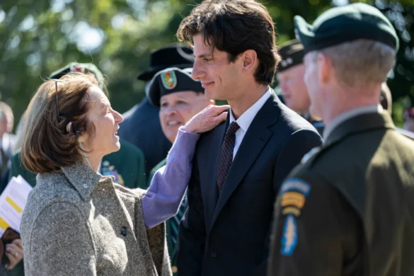 Public domain photo of people conversing at a formal outdoor event, including a man in a suit and others in military attire. Image Credits - U.S. Army photo by Elizabeth Fraser / Arlington National Cemetery / Public domain via Wikimedia Commons