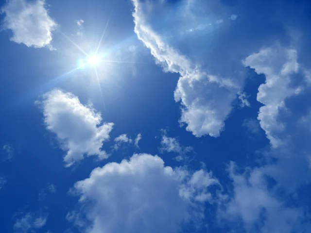 A clear blue sky with a few thin white clouds