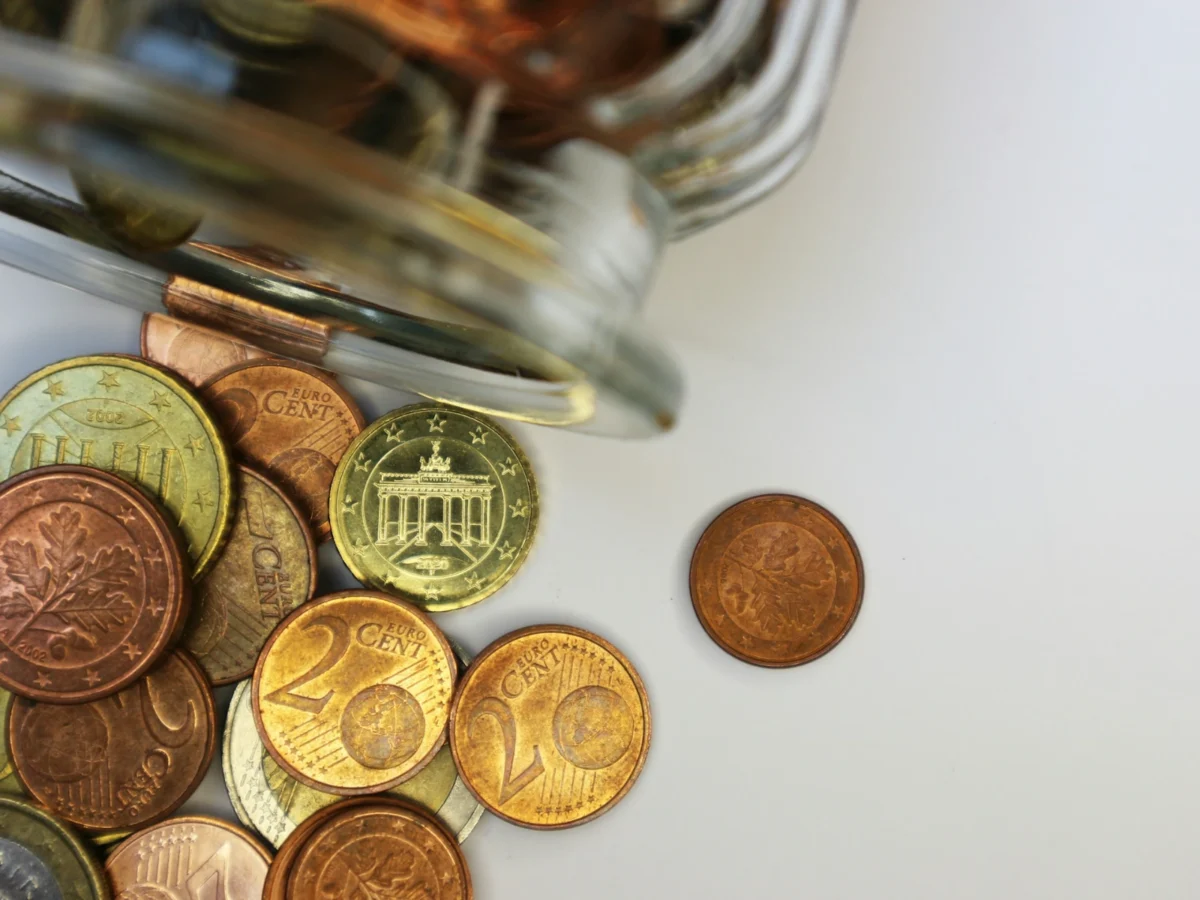 A glass jar filled with coins on a table