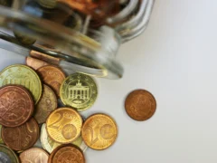 A glass jar filled with coins on a table