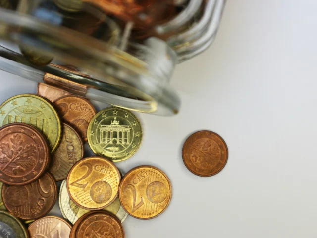 A glass jar filled with coins on a table