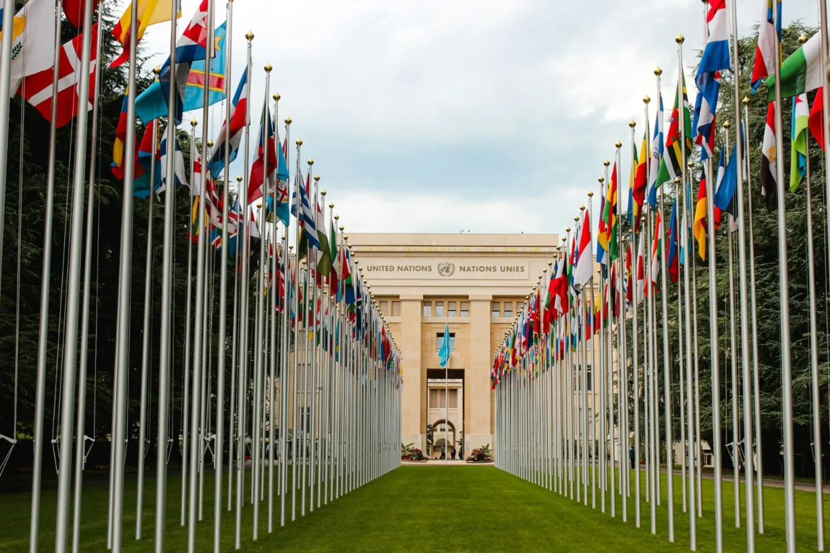Two rows of national flags leading to the Palais des Nations, the United Nations building in Geneva